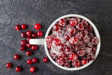 Cranberry with sugar on black background.