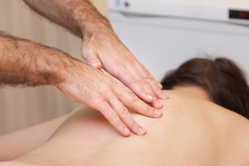 Fototapeta premium an experienced sports doctor makes medical massage for back and spine pain to a girl