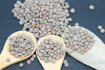 pardina lentils on black slate plate and wooden spoon