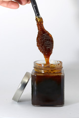 man catching honey from glass jar bees