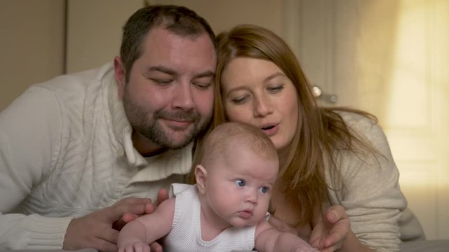 family mom dad and daughter lying on the bed