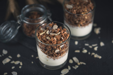 Homemade granola in glass on dark table