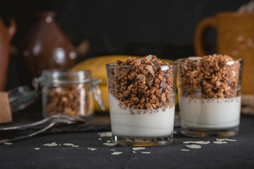 Homemade granola in glass on dark table