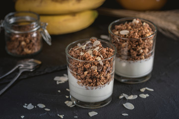 Homemade granola in glass on dark table