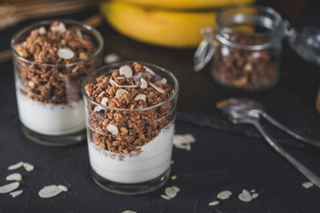 Homemade granola in glass on dark table