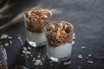 Homemade granola in glass on dark table