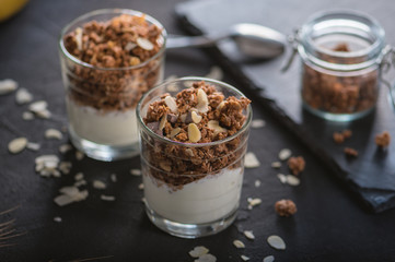 Homemade granola in glass on dark table
