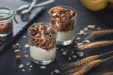Homemade granola in glass on dark table