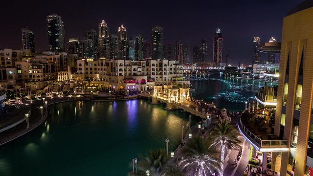 Tourists watching Dubai Fountain Show from Souk Al Bahar Bridge over Burj Khalifa Lake time lapse at night