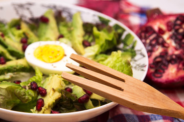 lettuce, avocado and pomegranate salad, diet and health concept