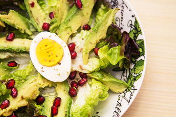 lettuce, avocado and pomegranate salad, diet and health concept