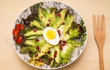 bowl with avocado lettuce and pomegranate