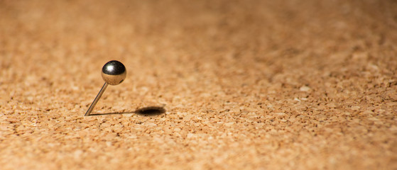 Metal pins on a cork board