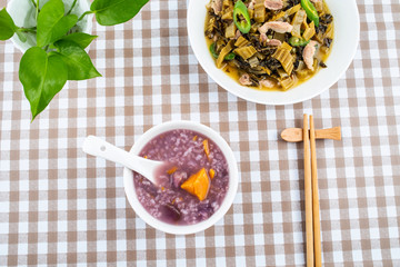 A plate of sauerkraut fried lean meat and a bowl of sweet potato porridge on the table