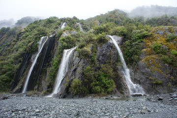 Fototapeta premium Beautiful waterfall in Franz Joseph Glacier trail, New Zealand.