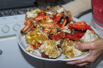 woman holding tray of cooked seafood