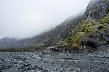 Mossy rock in Franz Joseph glacier trail walk,New Zealand.Hiking and camping in the misty morning.