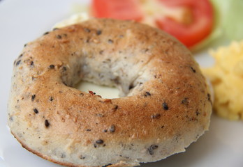 Toasted bagel with cheese, scrambled egg and salad