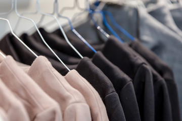 Kleidung auf Bügeln in Reihe in einem Geschäft