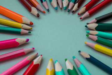 many multi-colored pencils on isolated on a blue background