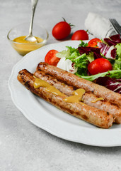 Healthy lunch grilled chicken sausages with tomato arugula salad. Top view copy space, chicken lunch recipe