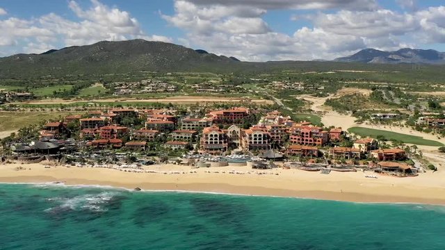 Aerial, hyper lapse, drone shot, over the ocean, towards hotels and resorts, at the Sheraton beach in Cabo San Lucas, Mexico