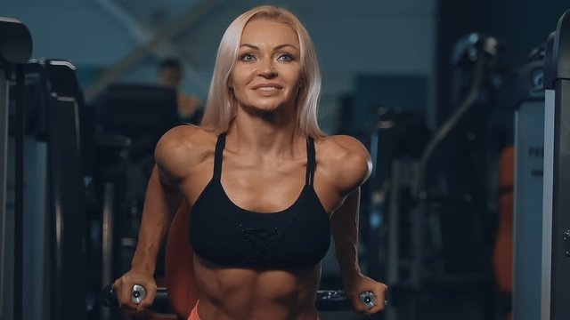 fitness pretty caucasian woman pumping up muscles chest pectorals workout fitness and bodybuilding concept gym background pectorals exercises in gym naked torso