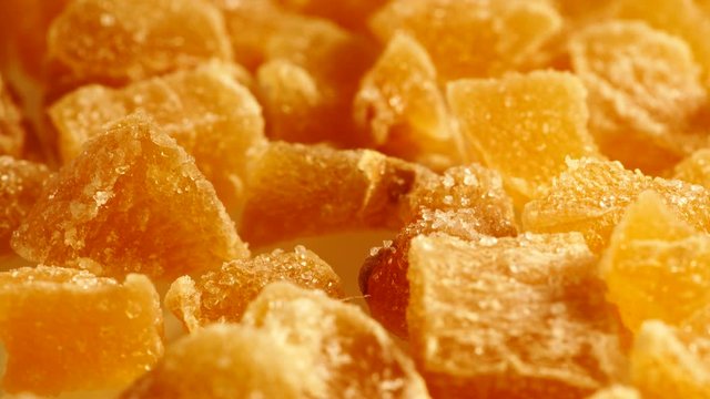Close up heap of crystallized candied ginger pieces rotating.  Yummy snack, better alternative to candy