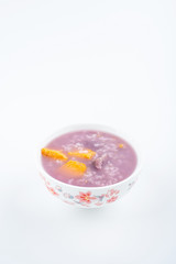 Purple sweet potato porridge in a bowl on white background