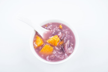 Purple sweet potato porridge in a bowl on white background