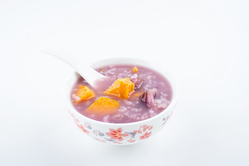 Purple sweet potato porridge in a bowl on white background