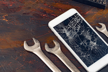 Smartphone repair concept. Damaged display of smartphone and tools