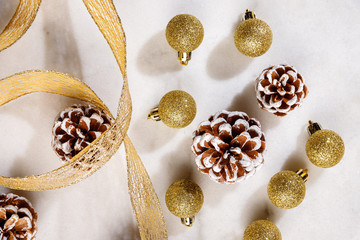 Festive christmas ornaments on white table and gold ribbon