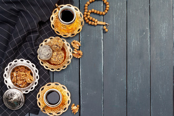 Nut balls dessert served with coffee on dark wooden table, top view