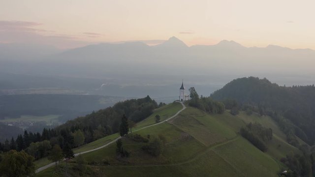 Sunrise over Jamnik, Slovenia. Aerial drone view over Alps and Church St. Primoz