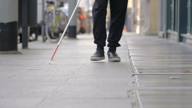 blind man walking on sidewalk in the city. autonomy,handicap