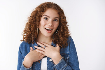 Surprised thankful cute girl receive unexpected compliment widen eyes amazed press palms gratefully...