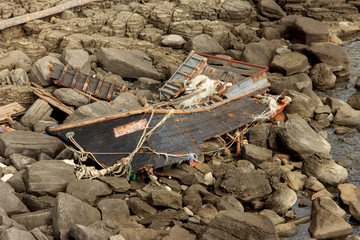 Vladivostok, Russia - September, 28, 2019: Wooden North Korean fishing boats thrown by a storm onto a rocky shore near Vladivostok.