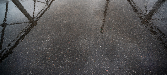 Wet dark asphalt with reflection of fences