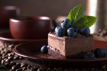 Chocolate cake with blueberries and mint .