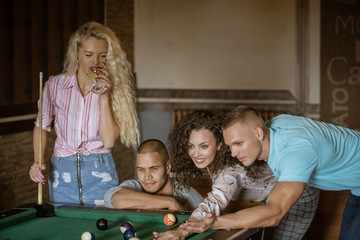 Obraz premium Young people playing snooker at bar