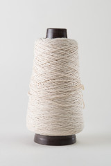  spool of thick white thread on a white background.