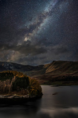 Obraz na płótnie Canvas Stunning majestic digital composite landscape of Milky Way over Hawes Water in Lake District