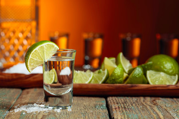 Tequila with  salt and lime on a old wooden background.