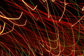 Glowing abstract Colorful light trail lines on dark background.