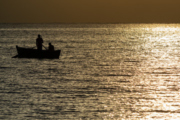 Seascape with fisherman boat, sun gleam