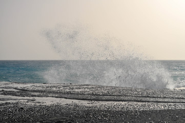 Waves of Aegean sea break about pier coast of the Crete