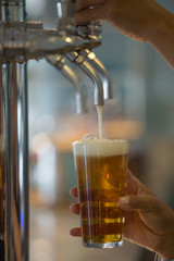 Fototapeta na wymiar close-up of woman's hand putting draft beer in a glass