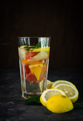 selective focus, a tall glass of water and citrus fruits