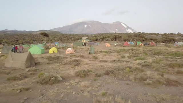 Drone approaching the Shira Camp, Kibo Peak in the background during Sunset. Expedition and mountaineering concept.